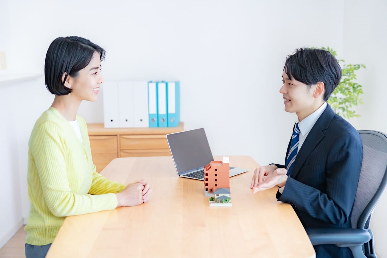 建物の模型を前に、担当者がお客様と話し合う様子